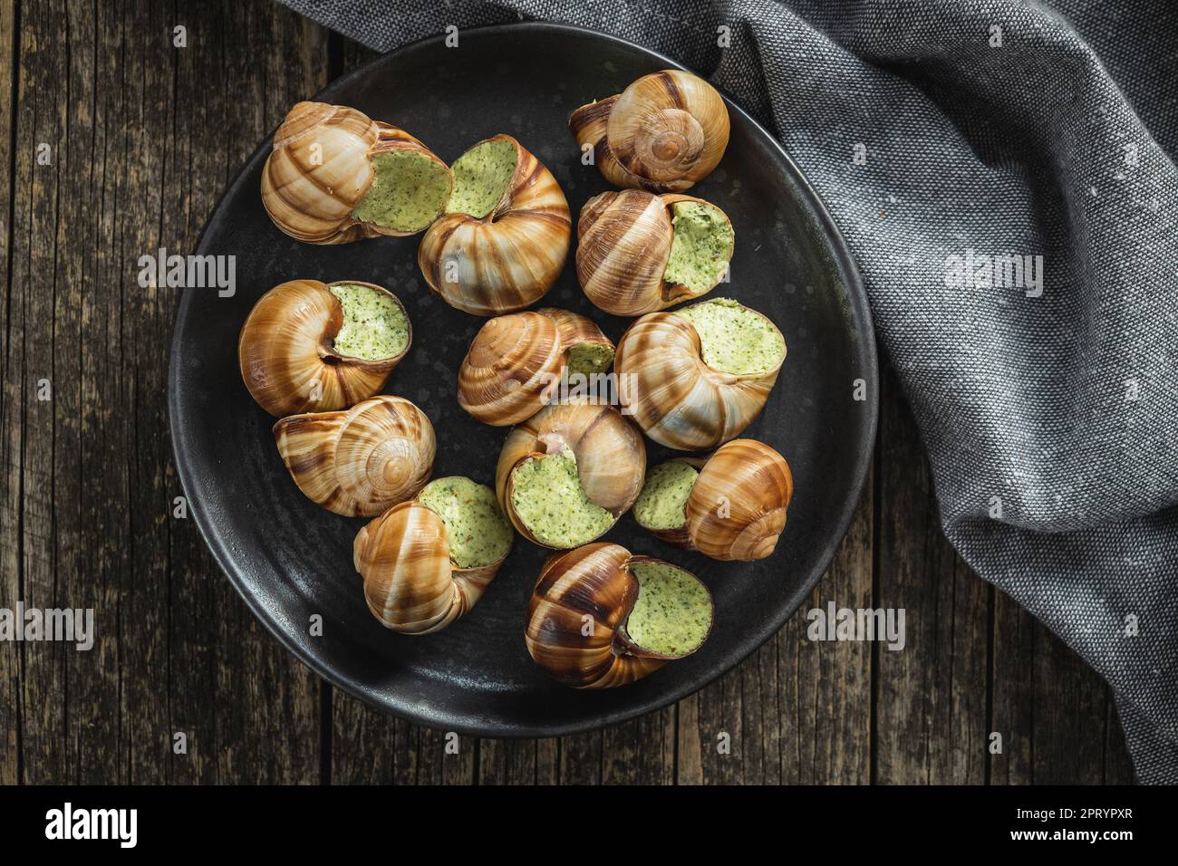 Schnecken mit Petersilienbutter, Bourgogne Escargot Schnecken auf dem Teller. Delikatesisches Essen. Draufsicht. Stockfoto