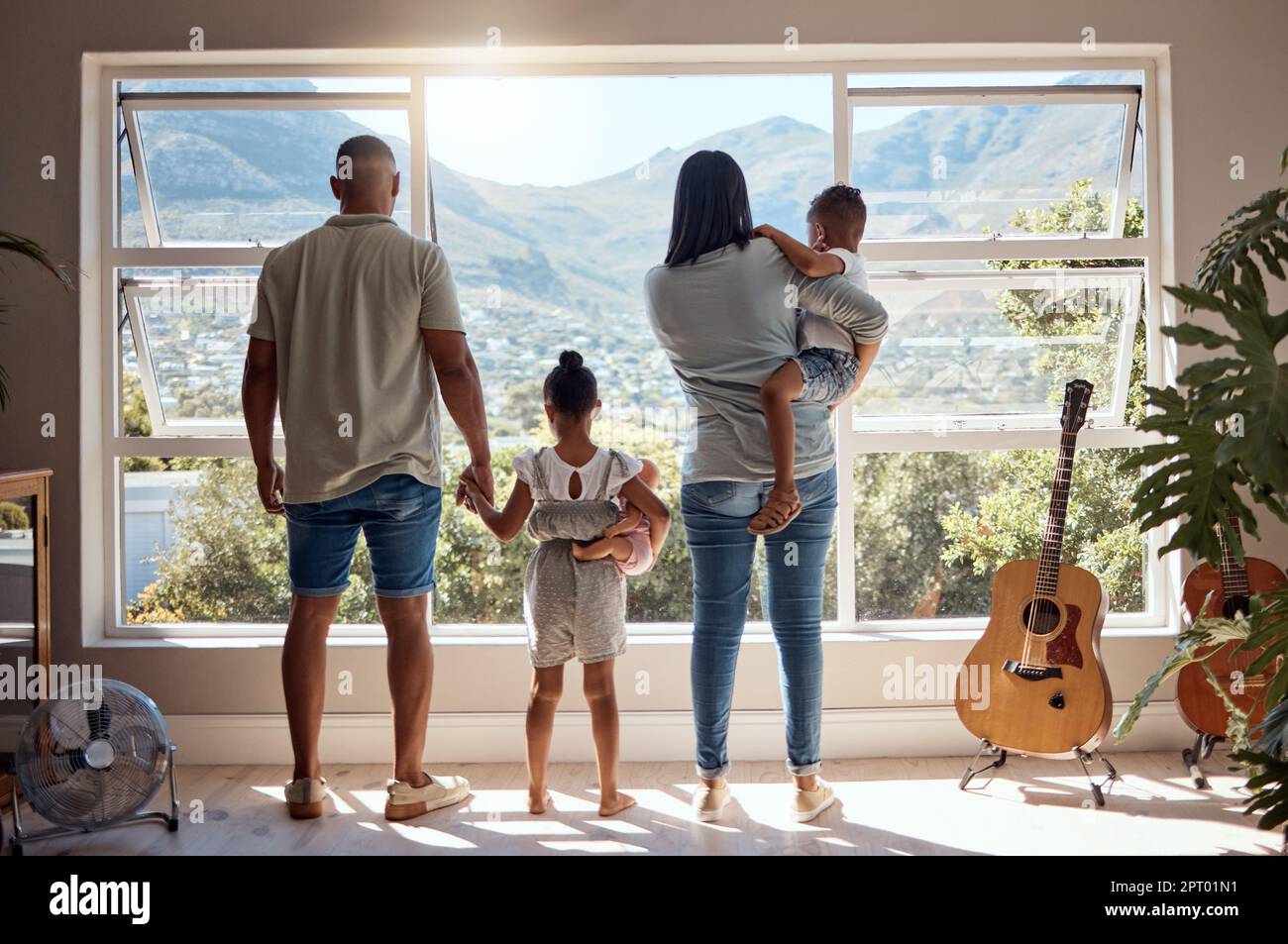 Familie, Liebe und Fenster mit Blick auf die Berge. Unterstützung, Vertrauen und Baby, Mutter und Vater halten die Hand eines Mädchens im Haus mit landschaftlich schönen Stockfoto