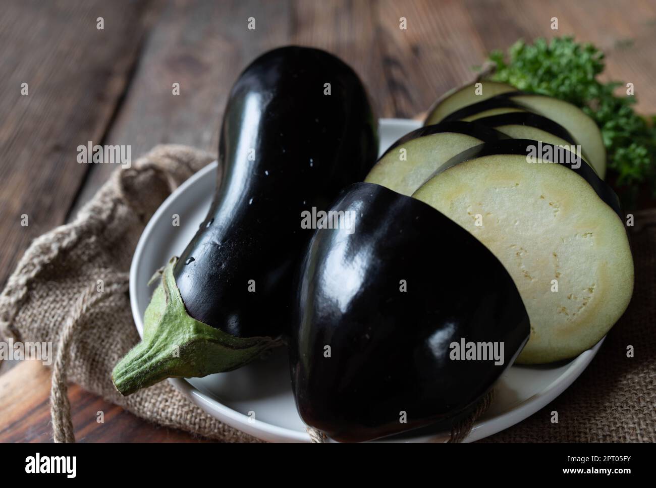 Rohe und nicht gekochte Auberginen auf Holztischhintergrund Stockfoto