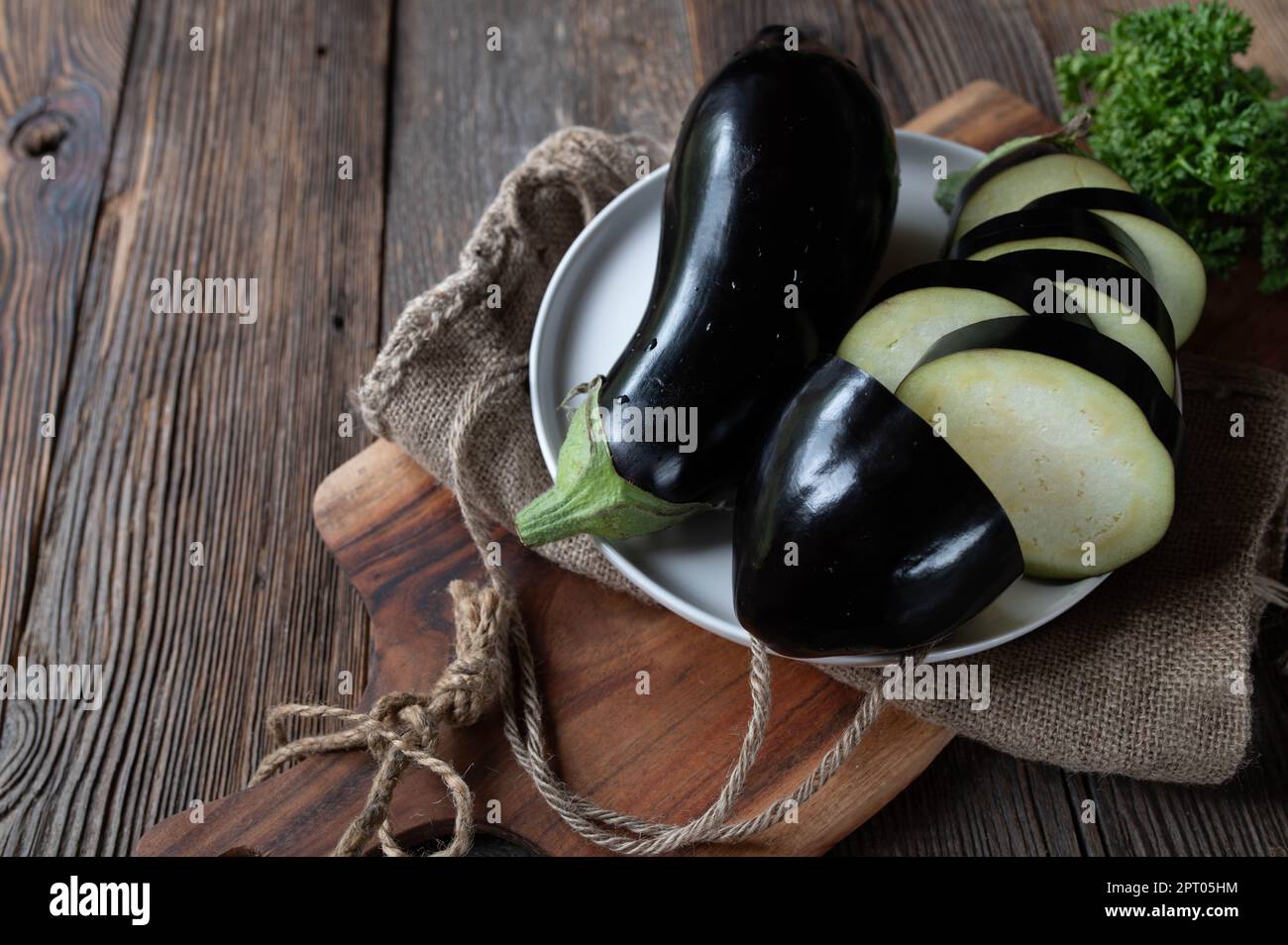 Rohe und nicht gekochte Auberginen auf Holztischhintergrund Stockfoto