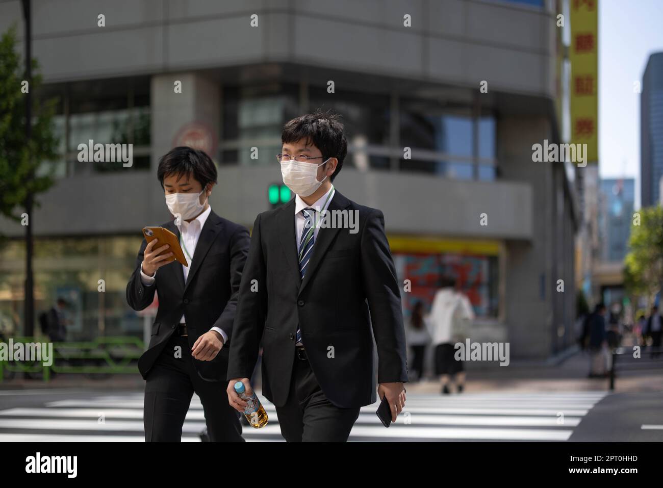 Tokio, Japan. 27. April 2023. Japanische Geschäftsleute mit Gesichtsmasken gehen über eine Kreuzung im Zentrum von Tokio. (Foto: Stanislav Kogiku/SOPA Images/Sipa USA) Guthaben: SIPA USA/Alamy Live News Stockfoto