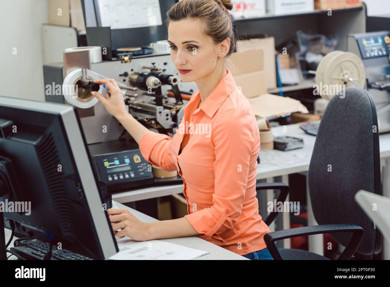 Frau Design Etiketten auf Etikettendrucker in der Werkstatt gedruckt werden, die auf Computerbildschirm Stockfoto