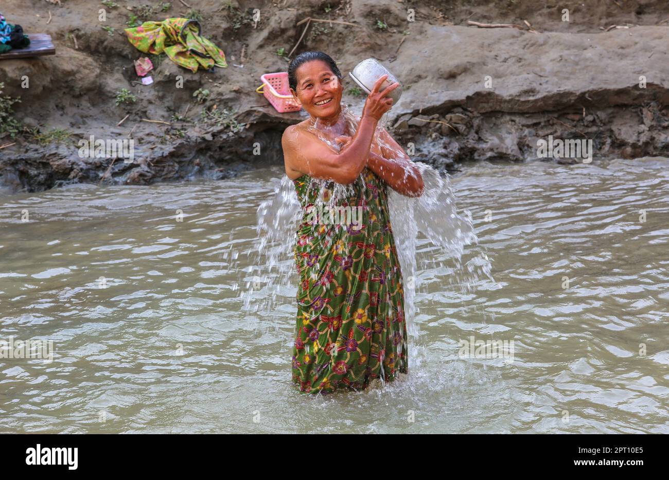 Birmanische Frau beim Baden und Waschen während der südostasiatischen Hitzewelle, Leben am Irrawaddy River, Hitzewellen-Rekorde, größte Wasserstraße in Myanmar (Burma) Stockfoto