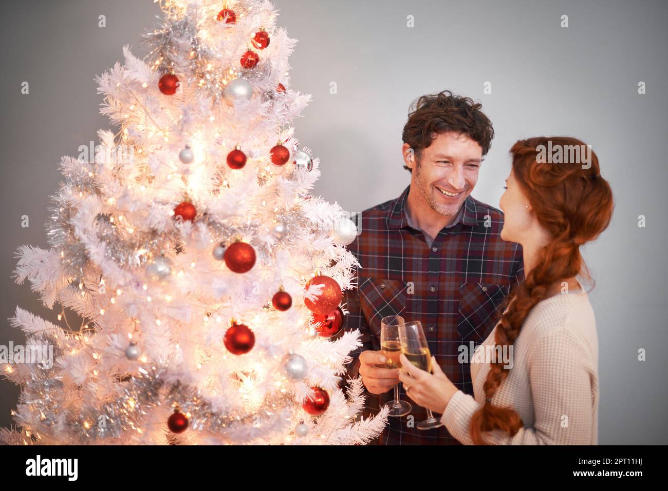 Alles, was ich zu Weihnachten will, sind Sie. Ein liebevolles Paar genießt Champagner an ihrem Weihnachtsbaum Stockfoto