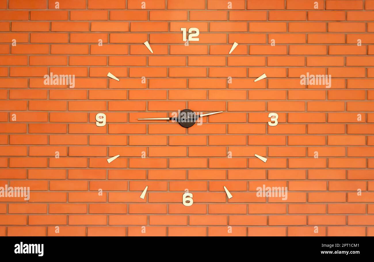 Eine große Uhr an einer Ziegelwand. Kann als Hintergrundbild verwendet werden. Stockfoto