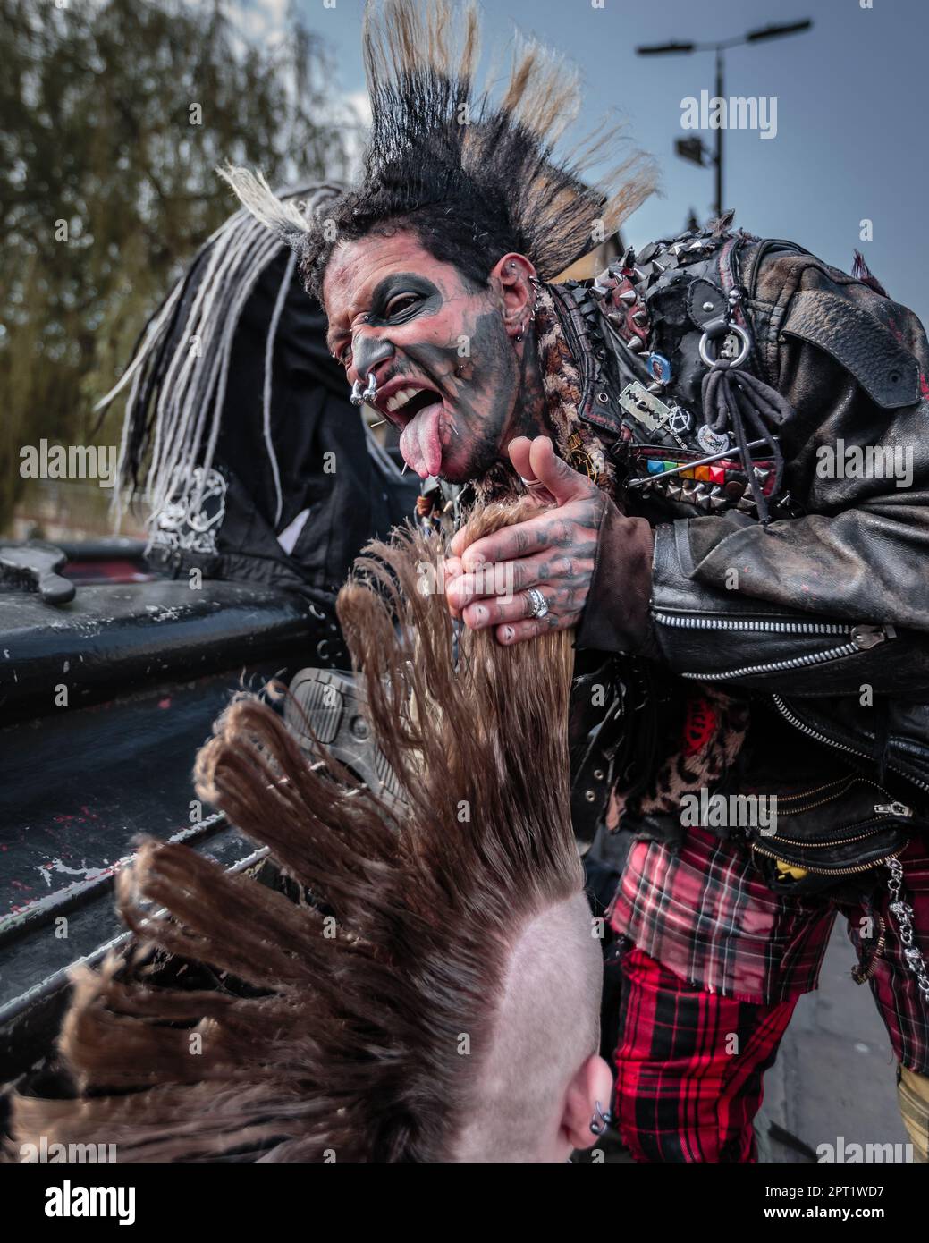 Ein Punk hilft einem Freund mit seiner mohikanischen Frisur in Camden, London. Stockfoto