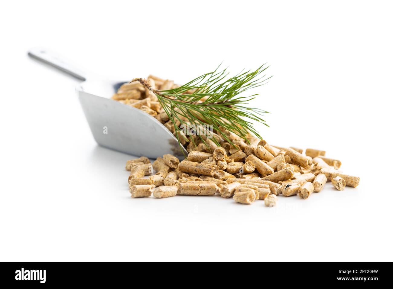 Holzpellets in Schaufel und Kiefernzweig isoliert auf dem weißen Hintergrund. Stockfoto