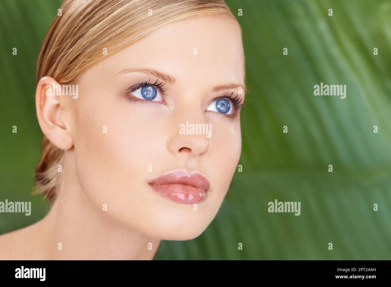 Ganz natürlich. Nahaufnahme einer schönen Frau vor dem Hintergrund grüner Palmenfronten Stockfoto