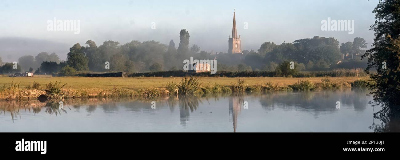 LECHLADE, GLOUCESTERSHIRE, Großbritannien - 04. JULI 2008: Panoramablick über die Themse in Richtung St. Lawrence Kirche in sanftem Morgenlicht mit Reflexion Stockfoto