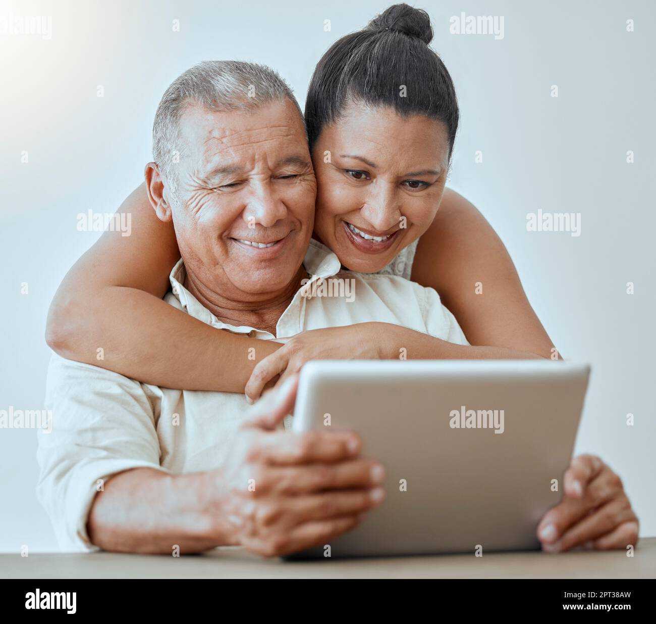 Tablet, Internet und viel Spaß mit einem älteren Paar, das zusammen zu Hause mit Wireless-Technologie im Internet surft. Beziehung, Lächeln und glücklich mit einem e Stockfoto