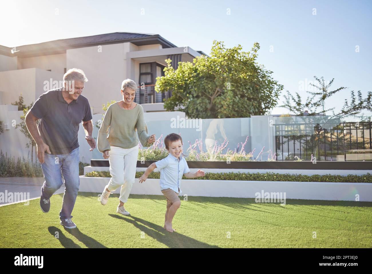 Familienlauf, fröhlicher Garten und Kind mit Großeltern auf dem Rasen