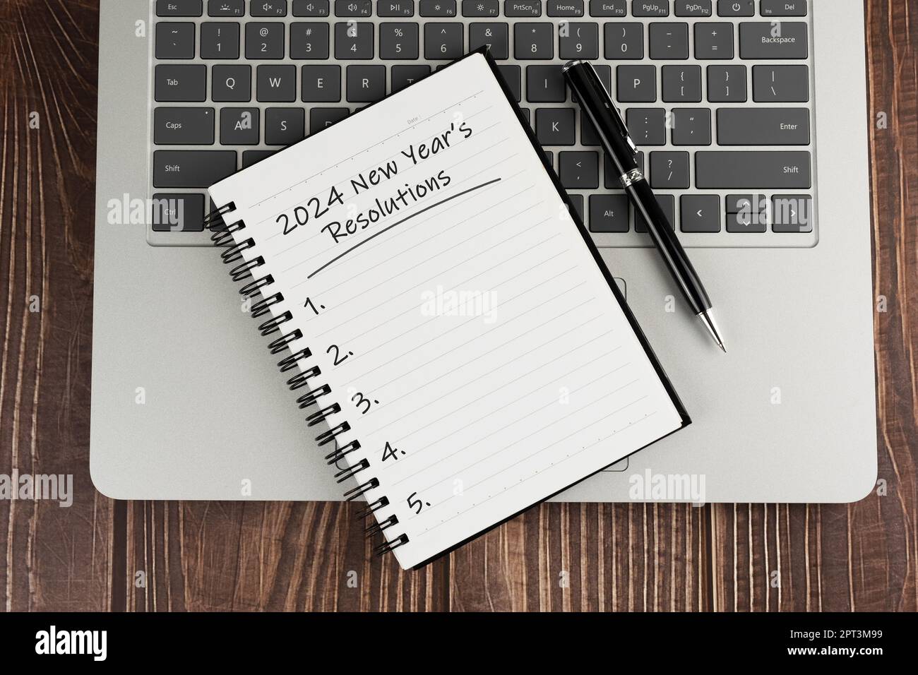 Laptop und Notizblock mit Text – Neujahrsvorsätze 2024 Stockfoto