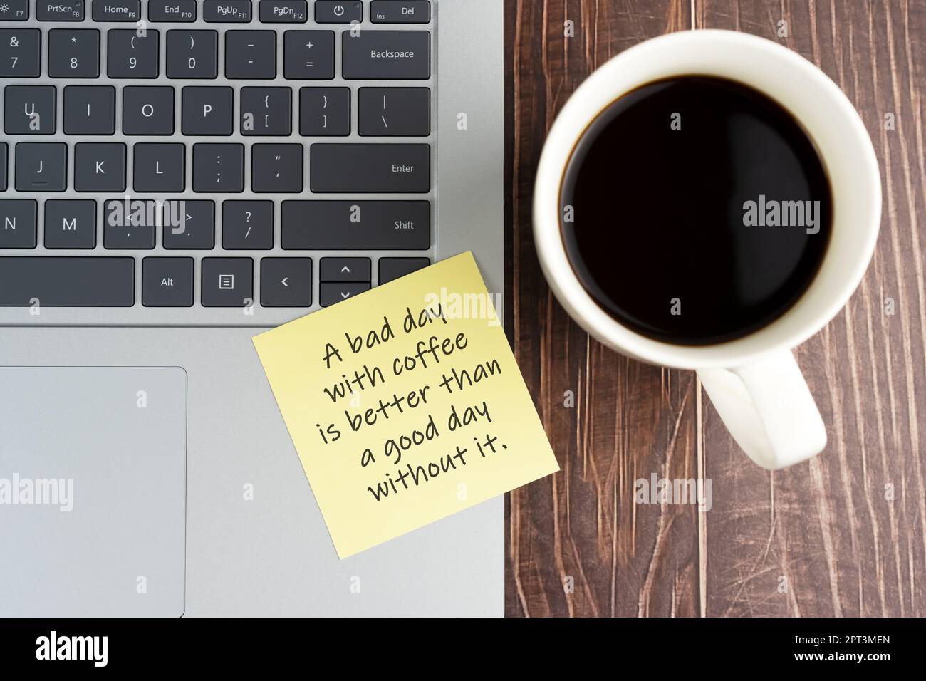 Laptop und Haftnotiz einer Kaffeetasse mit Text – Ein schlechter Tag mit Kaffee ist besser als ein guter Tag ohne Kaffee. Stockfoto