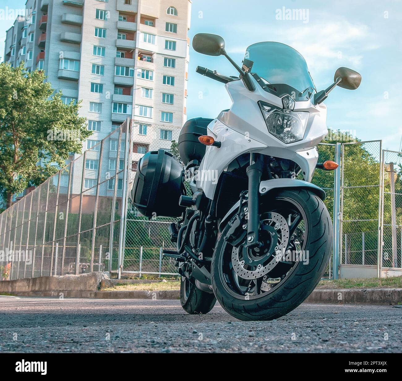 Weißes Motorrad steht auf einer Plattform in der Stadt Stockfoto