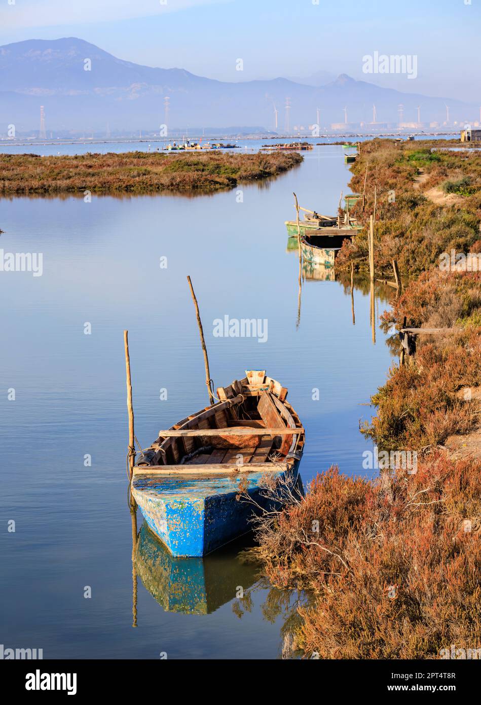 Sardinien, Italien, 2022. Dezember - Altes hölzernes Ruderboot am Pier auf dem Wasser. Stockfoto