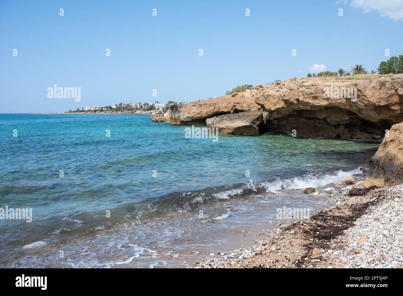 Felsformationen in Meereshöhlen, Kiesstrand und türkisfarbenes Wasser in Melanos, Zypern Stockfoto