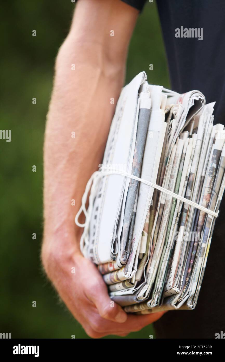 Bereit zum Recycling. Ein Mann mit einem Stapel Zeitungen Stockfoto