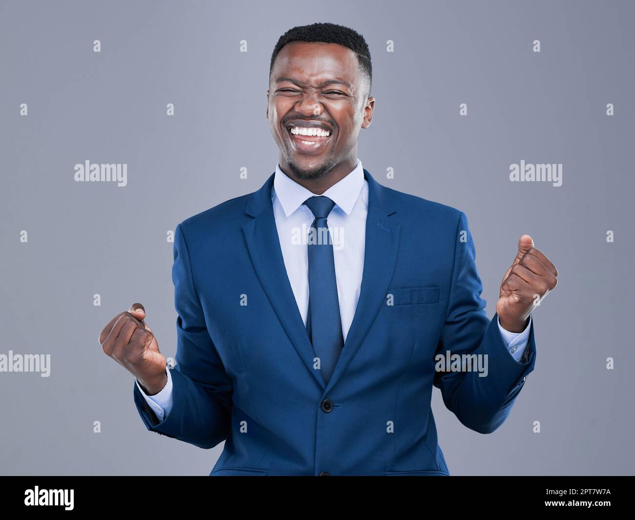 Erfolg ist da, um sich zu nehmen. Ein gutaussehender junger Geschäftsmann, der im Studio vor grauem Hintergrund jubelt Stockfoto