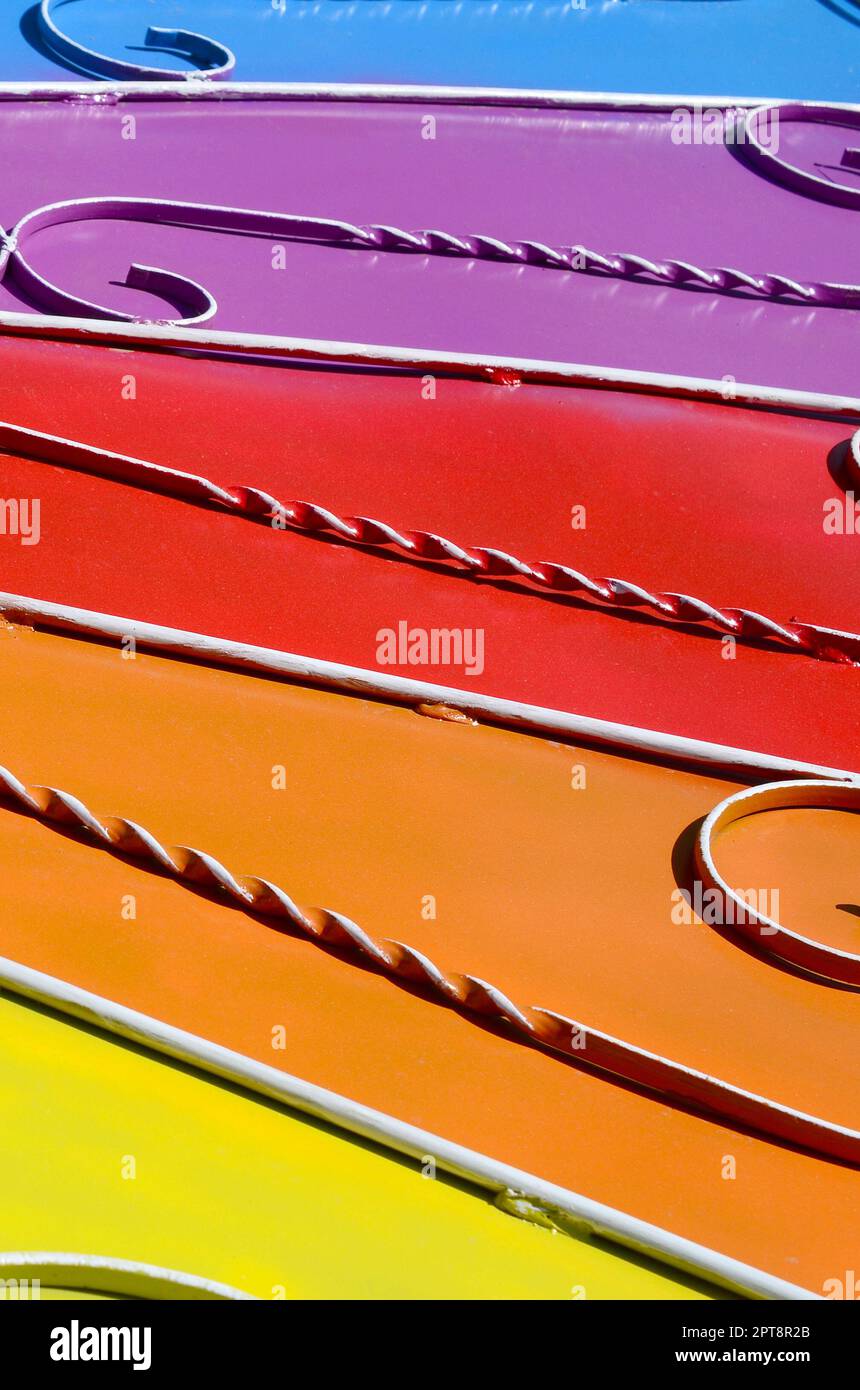Metall Textur eines Stück farbige Wand mit einem geschmiedeten Muster. Regenbogen Farben Stockfoto