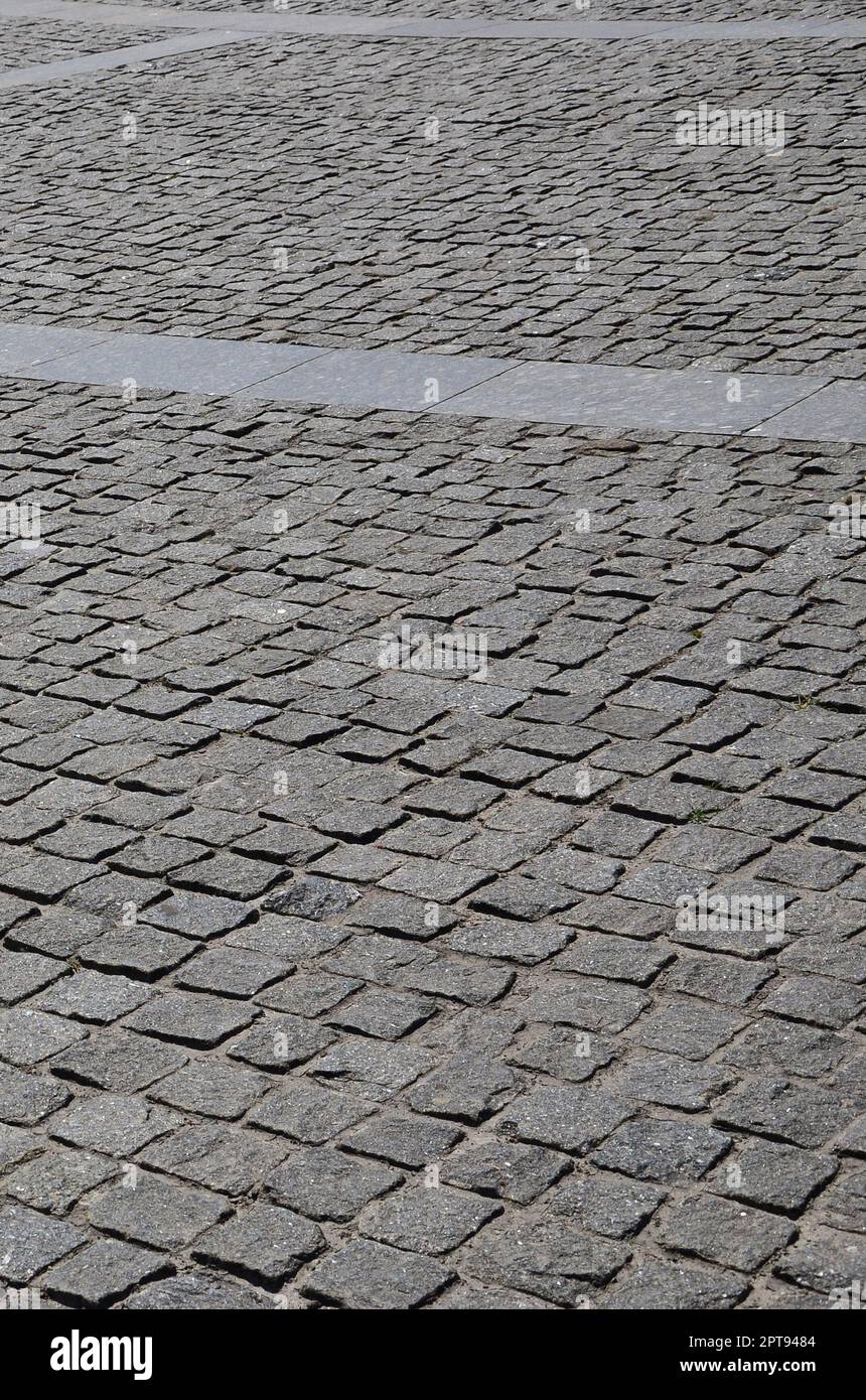 Die Textur der Pflasterung Tafel (pflastersteine) von vielen kleinen Steinen einer quadratischen Form unter hellem Sonnenlicht Stockfoto