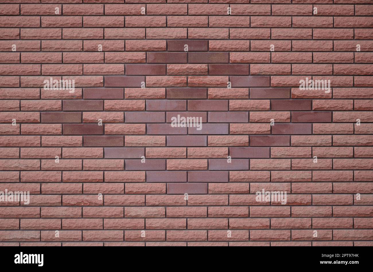Die Beschaffenheit der Wände der Moderne und qualitativ hochwertige Stein Ziegel. Glatte Textur rosa Mauer im hellen Sonnenlicht tagsüber im Freien Stockfoto
