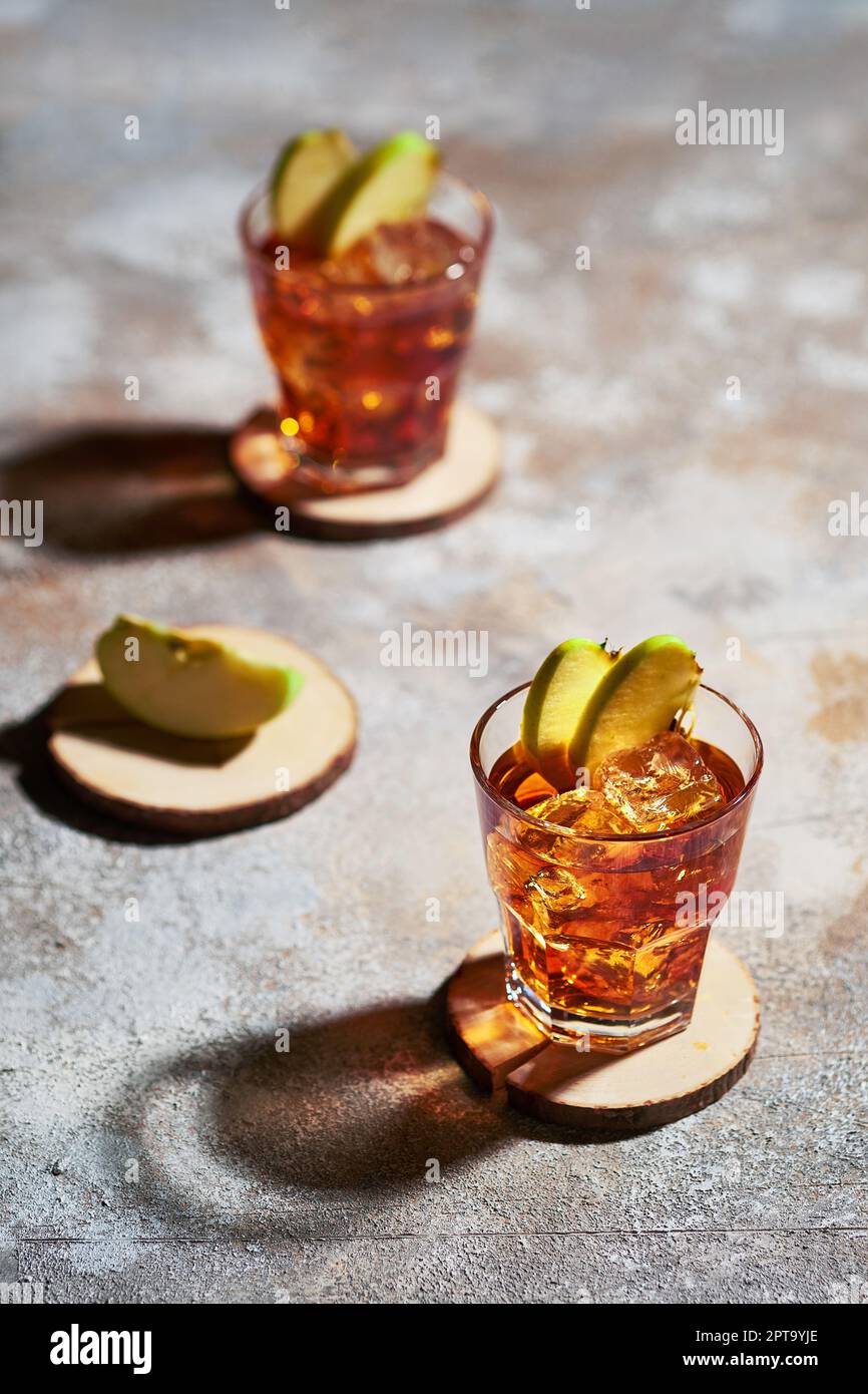 Apfelsaft Whiskey Cocktail unter hartem Sonnenlicht Stockfoto