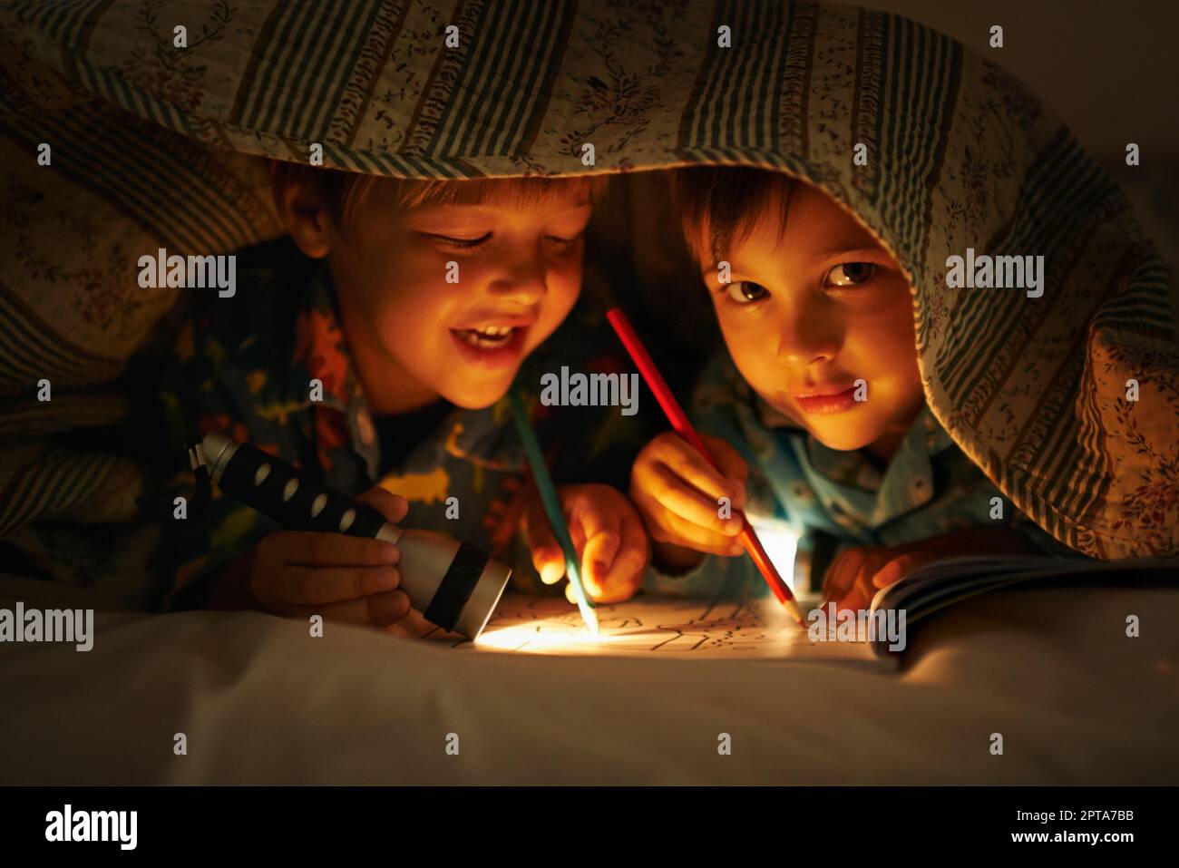 Hey, du gehst über die Linien. Porträt zweier Brüder, die mit einer  Taschenlampe unter ihrer Bettfarbe liegen Stockfotografie - Alamy