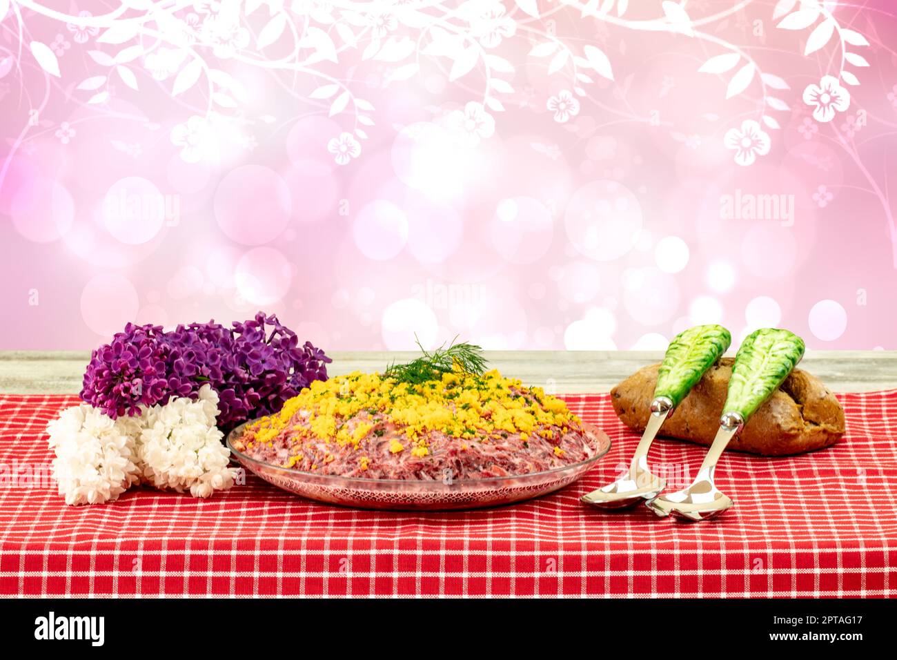 Traditioneller russischer Salat mit dem Namen Hering unter einem Pelzmantel. Traditionelle russische Küche auf einem rustikalen Tisch mit abstrakten Blumen. Konz Stockfoto
