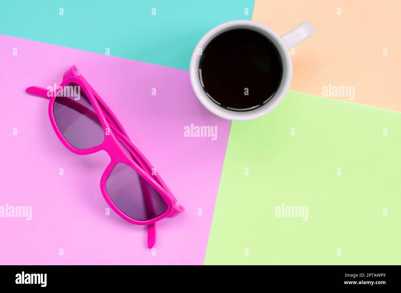 Kleine weiße Tasse und rosa Sonnenbrille auf Textur Hintergrund der Mode Pastell rosa, blau, Koralle und Kalk Farben Papier in minimalen Begriff. Stockfoto