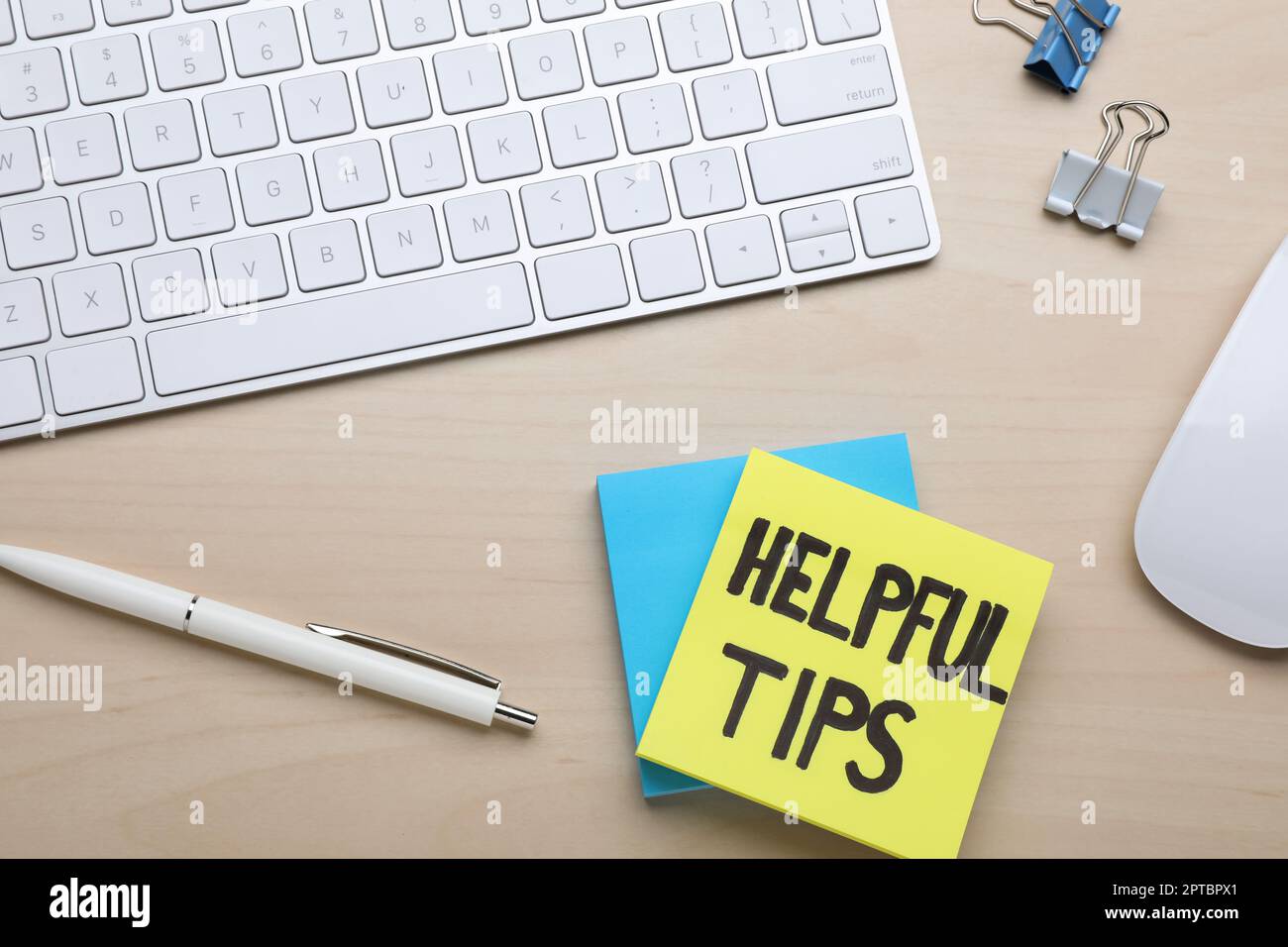 Hilfreiche Tipps. Computertastatur, Maus und Schreibwaren auf Holztisch, flach liegend Stockfoto