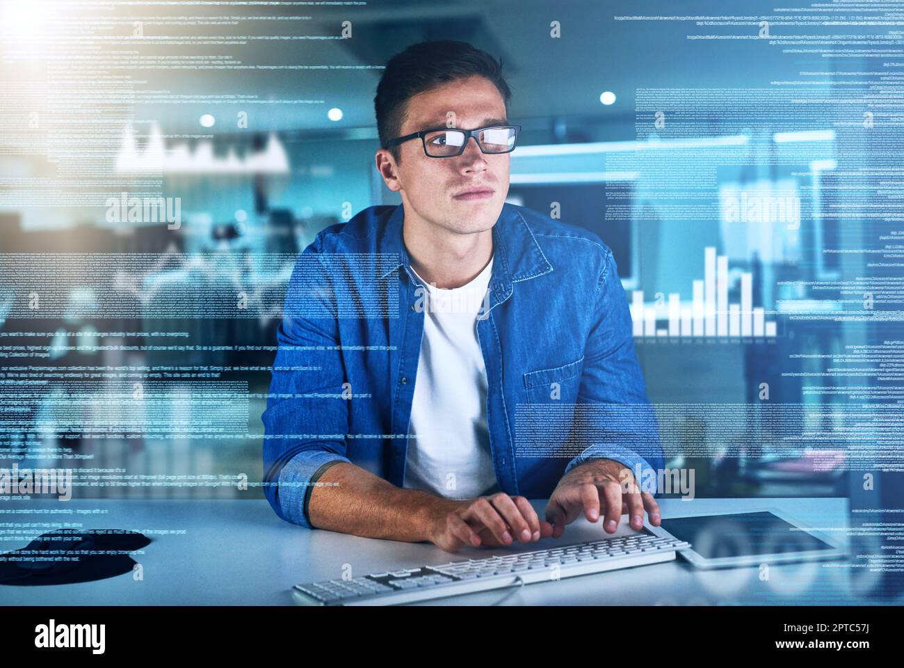 Fokussiert und bereit, Arbeit zu erledigen. Ein fokussierter junger Programmierer, der nachts an seinem Computer im Büro arbeitet Stockfoto