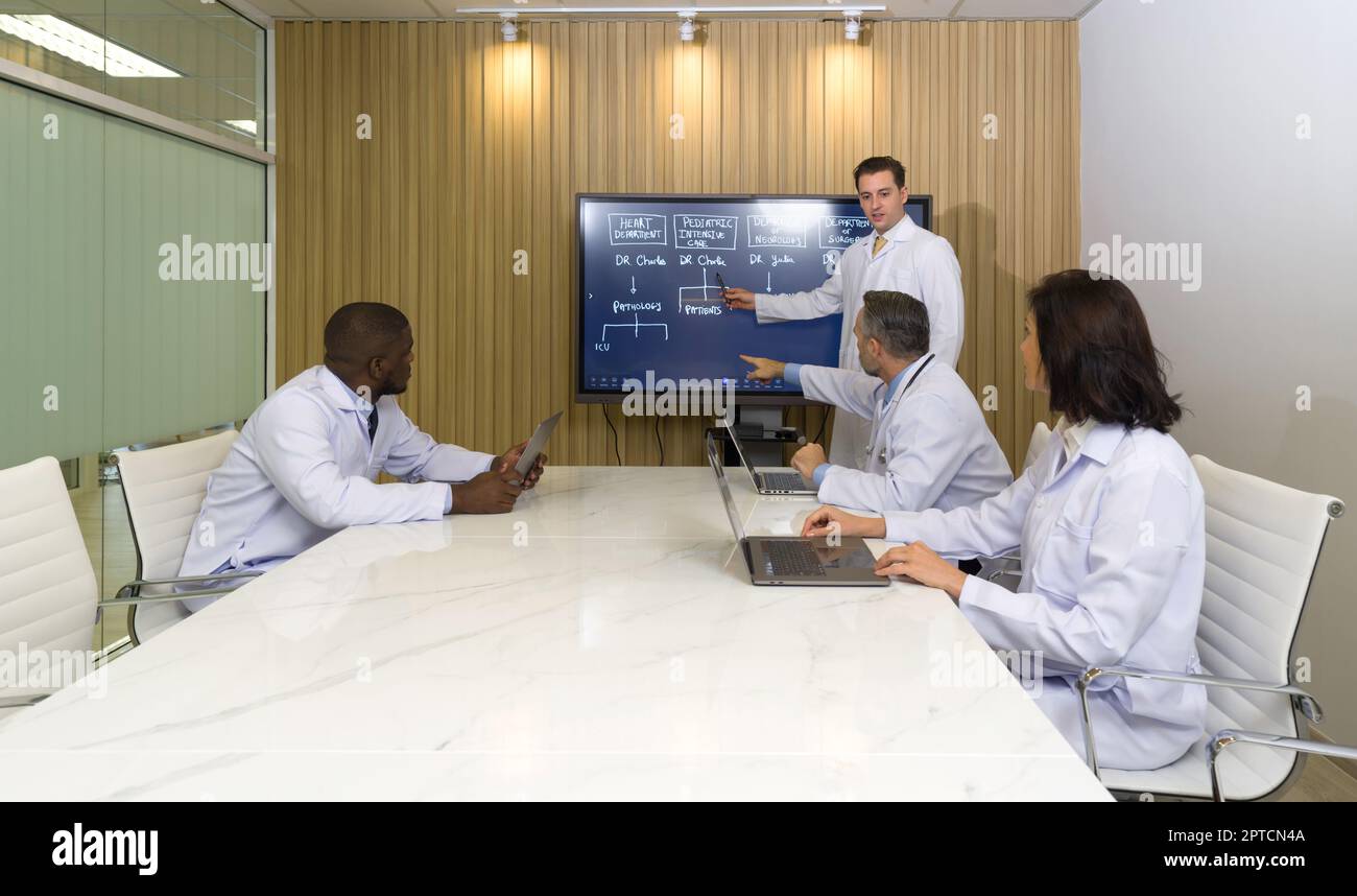 An der Jahrestagung nehmen Direktor verschiedener Abteilungen des Krankenhauses Teil. Der Konferenzleiter verwendet für Präsentationen einen Flachbildfernseher. Jeder hat Th Stockfoto