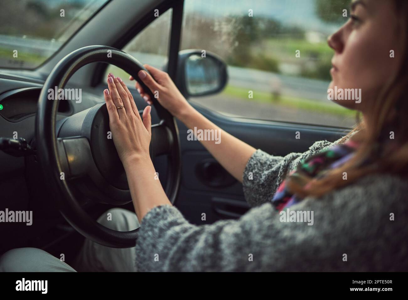 Da vorne ist ein bisschen Verkehr. Eine junge Frau, die ihr Auto fährt Stockfoto