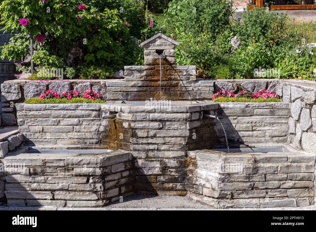 Typischer Brunnen der italienischen Alpenländer Stockfoto