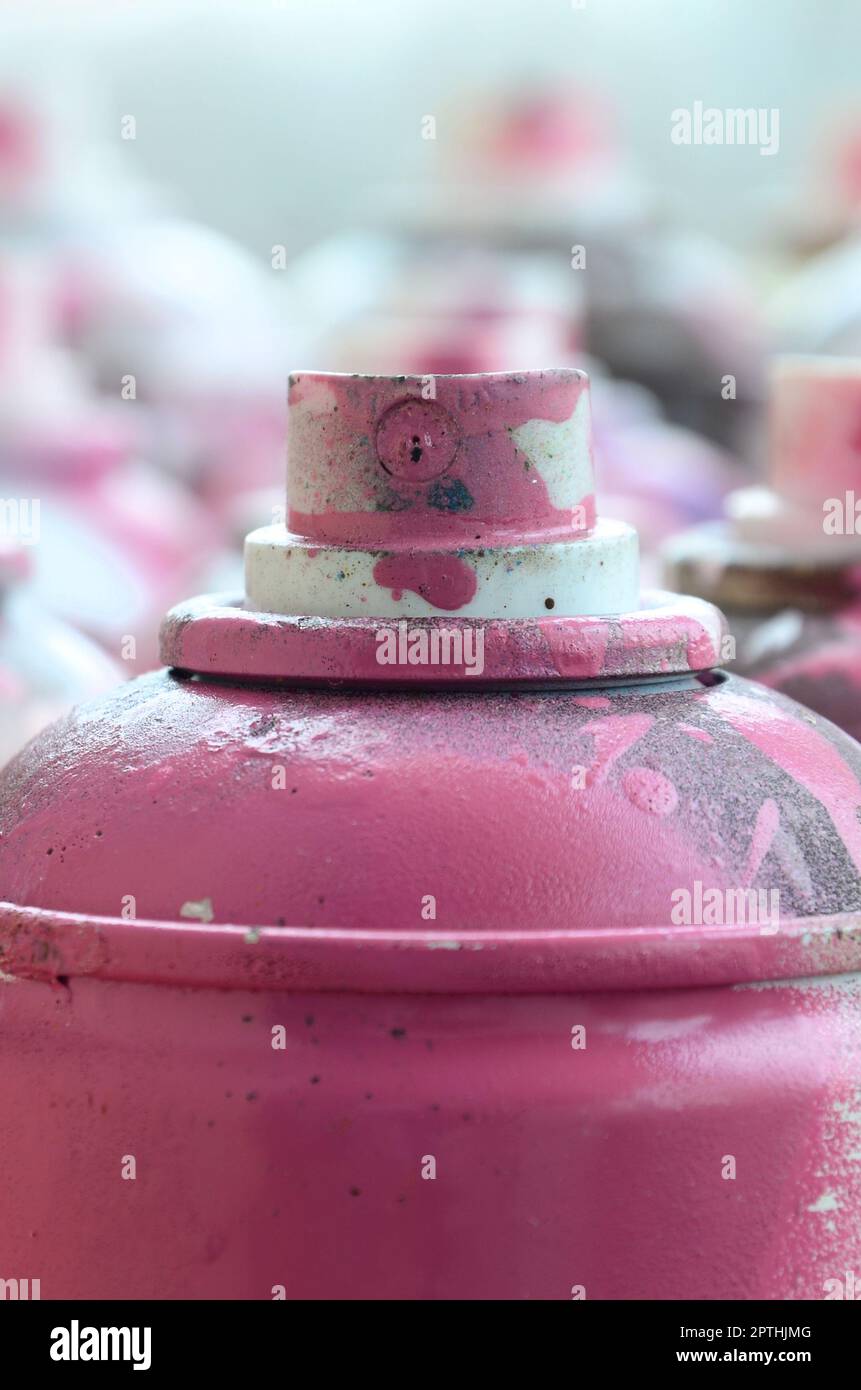 Eine Menge schmutzige und Aerosoldosen von hell-rosa Farbe. Makro Foto mit geringer Tiefenschärfe. Selektiver Fokus auf der Spritzdüse Stockfoto