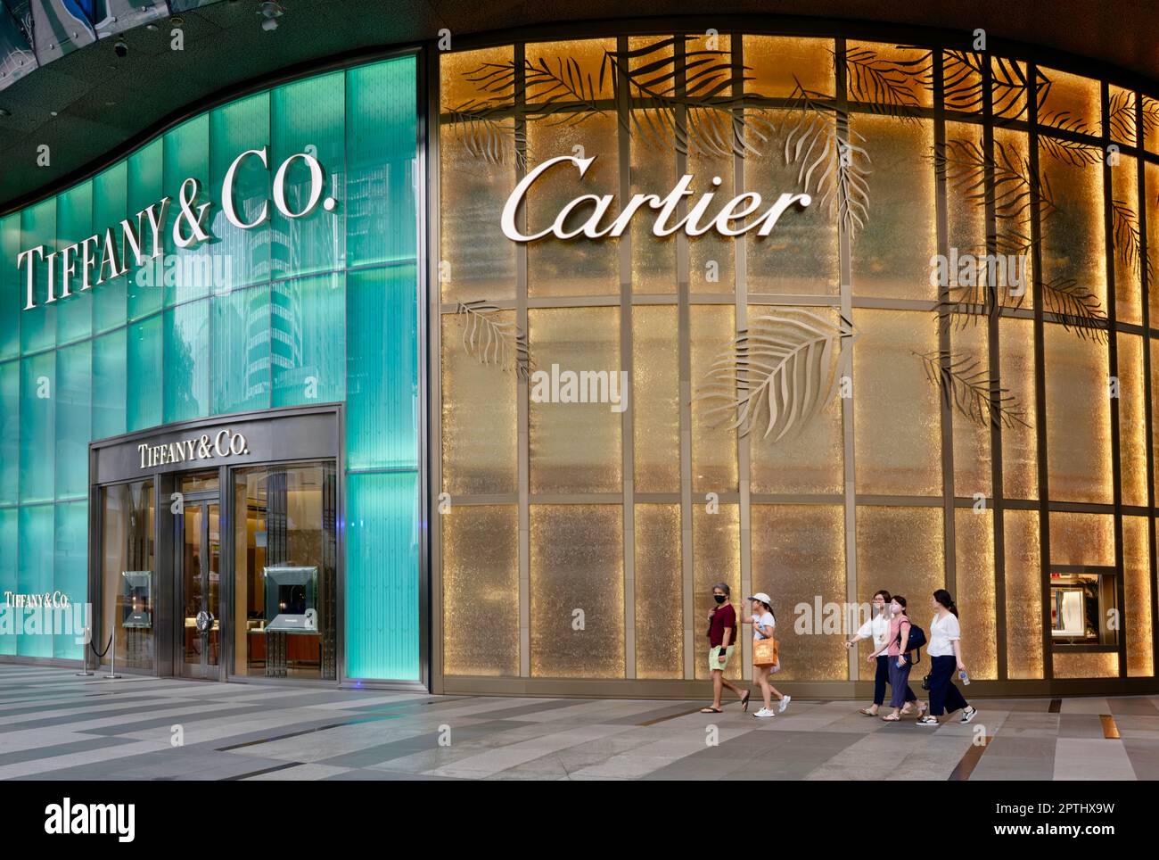 Shoppers passieren Cartier und ein Tiffany Co. Outlet im ION Orchard Einkaufszentrum in der luxuriosen EinkaufsstraBe Orchard Road in Singapur Stockfotografie Alamy