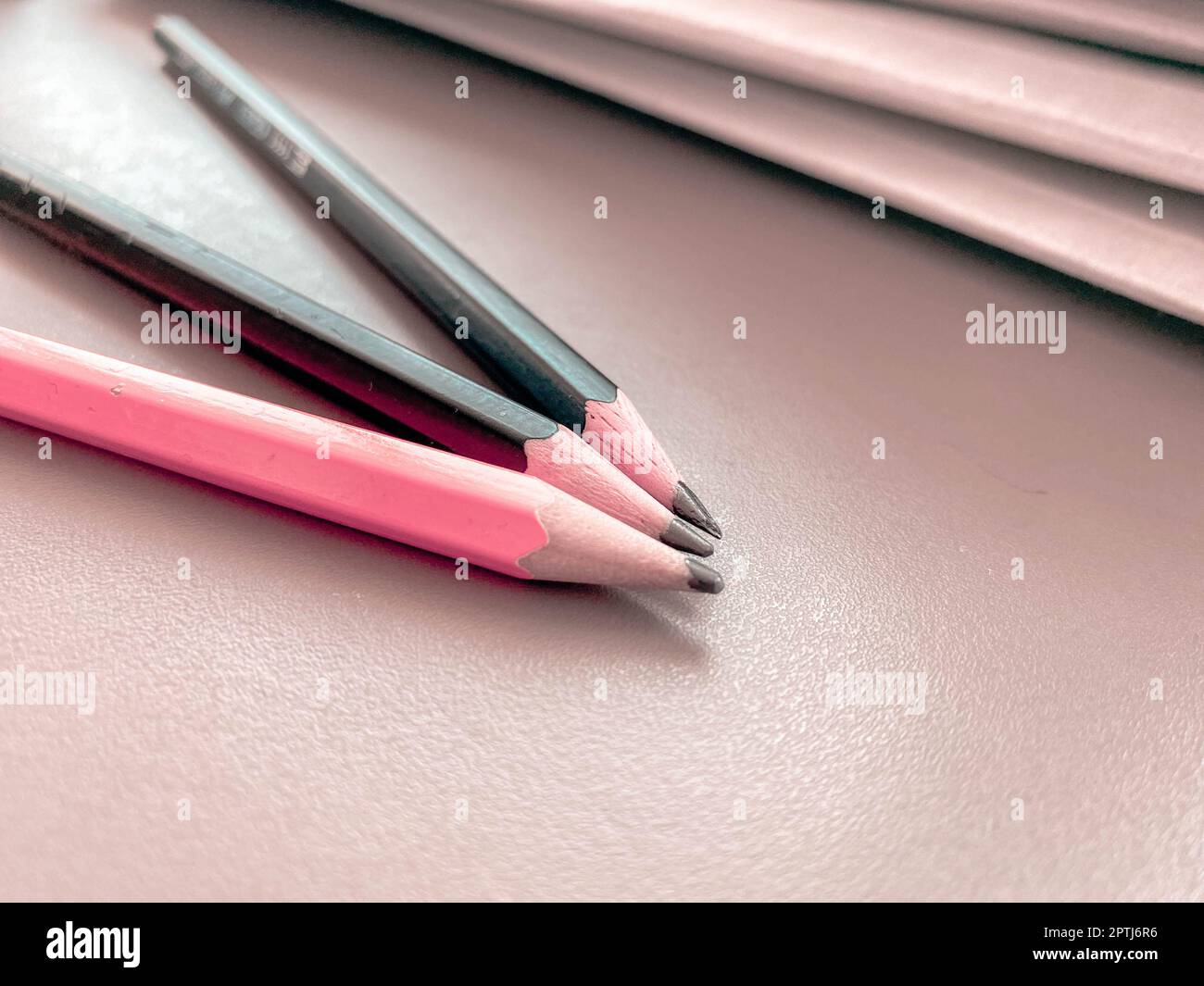Drei Bleistifte liegen scharf gespitzt neben Ordnern mit Blättern und Dokumenten auf dem Büroschreibtisch im Büro. Briefpapier. Stockfoto