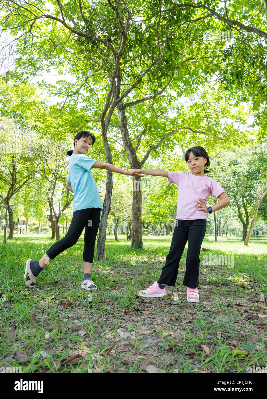 Zwei glückliche Mädchen mit einem Lächeln im Freien im Park. Kinder spielen und genießen den Sommertag im grünen Park. Stockfoto