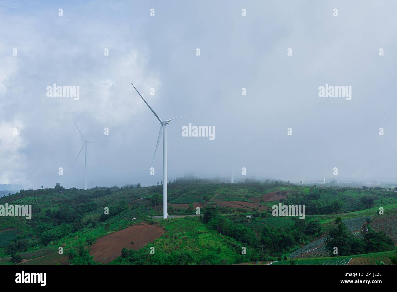 Landschaft von Hügeln und Windkraftanlagen mit nebligen Nebel in der Morgenzeit. Stockfoto