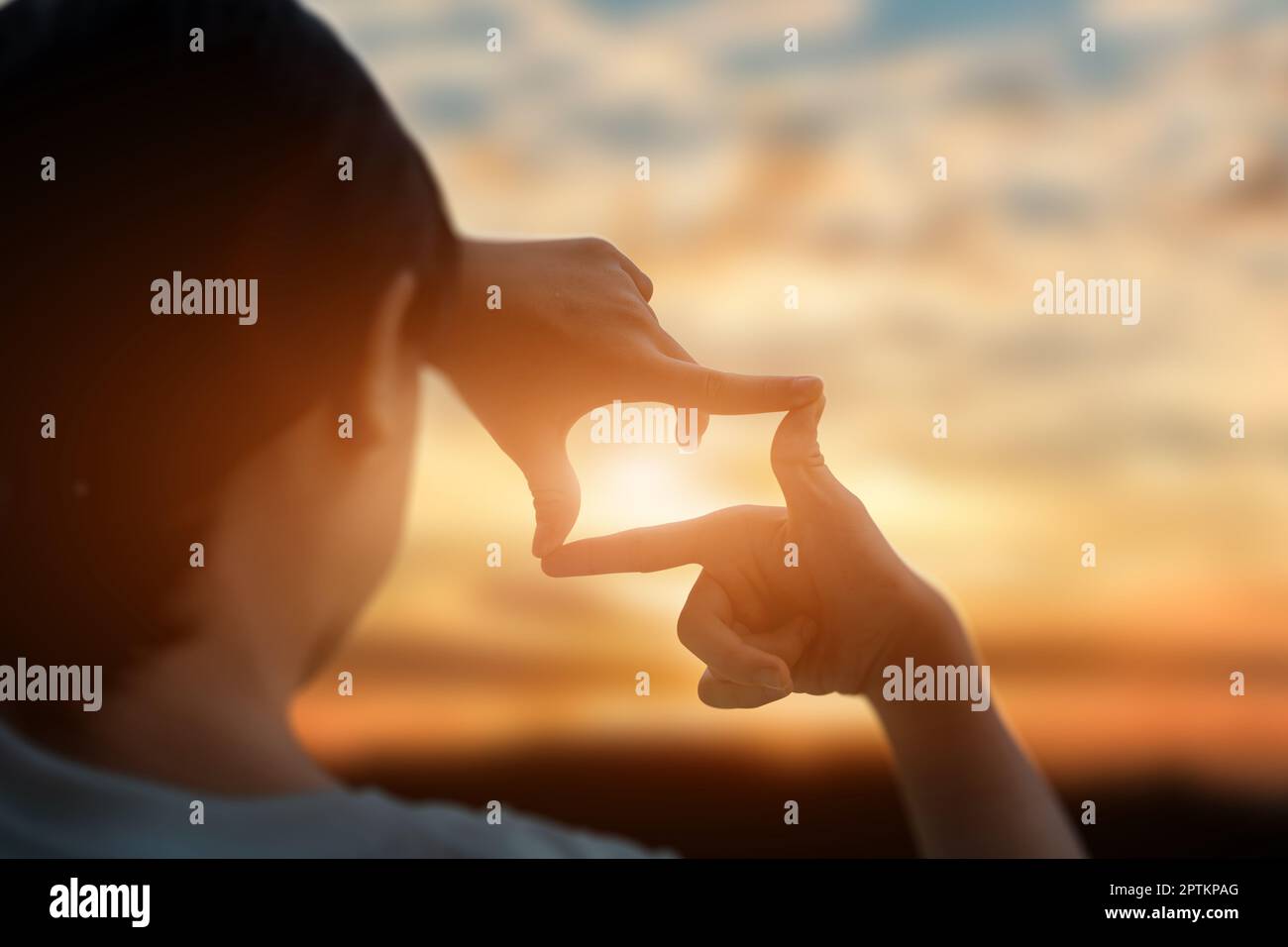 Zukunftsplanungskonzept. Nahaufnahme der Hände einer jungen Frau, die ein Rahmenschild über dem Sonnenuntergang macht. Neujahrsplanung und Visionskonzept. Stockfoto