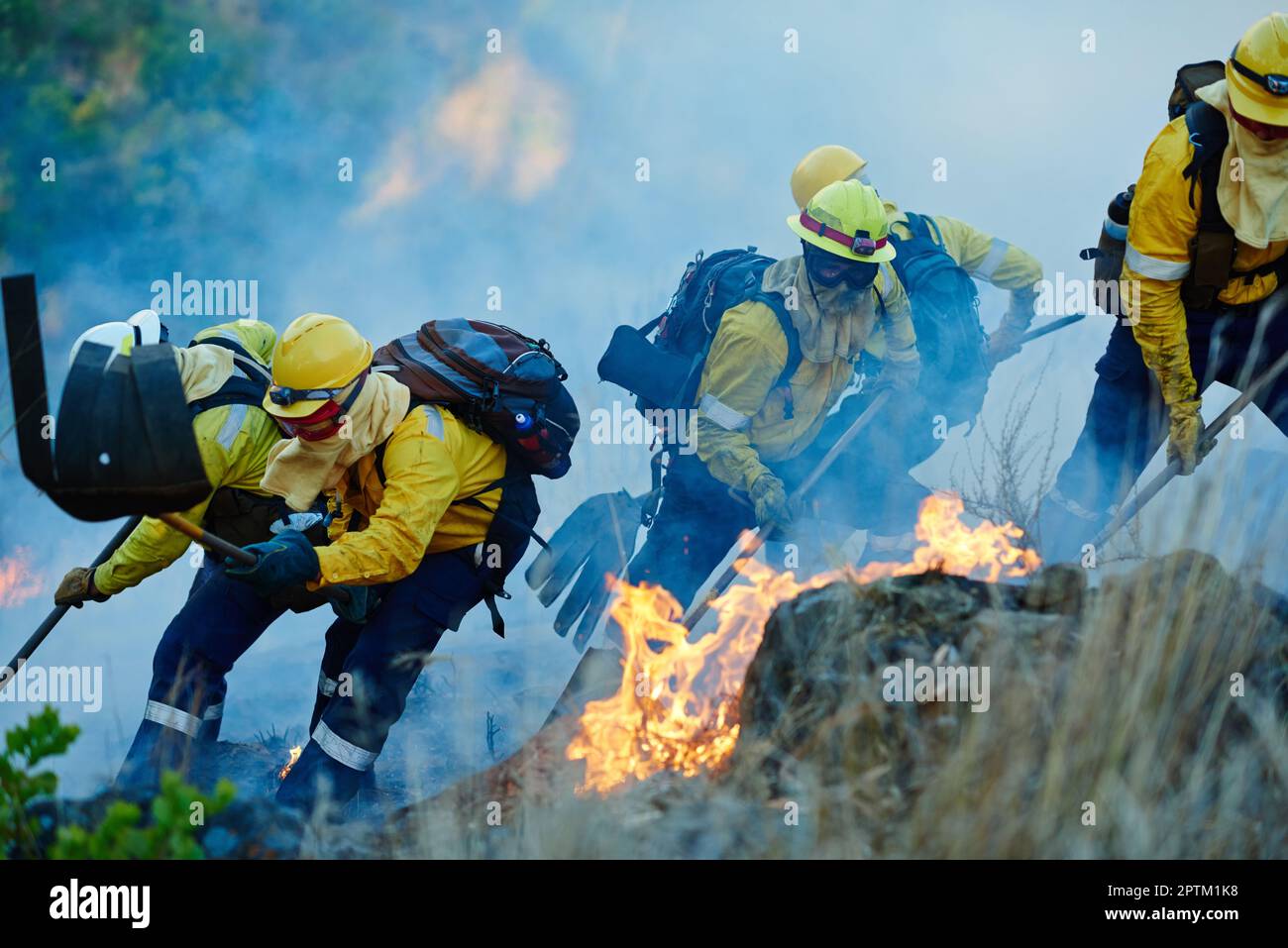 Feuer mit Mut bekämpfen. Feuerwehrleute bekämpfen ein Feuer Stockfoto