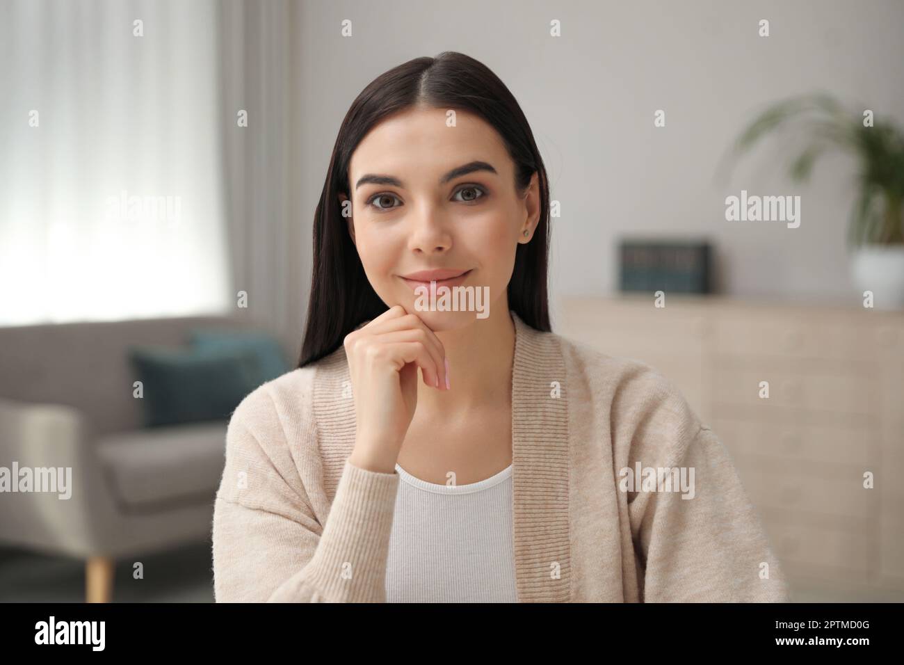 Schöne junge Frau, die ein Webinar im Raum veranstaltet, Kameraansicht Stockfoto