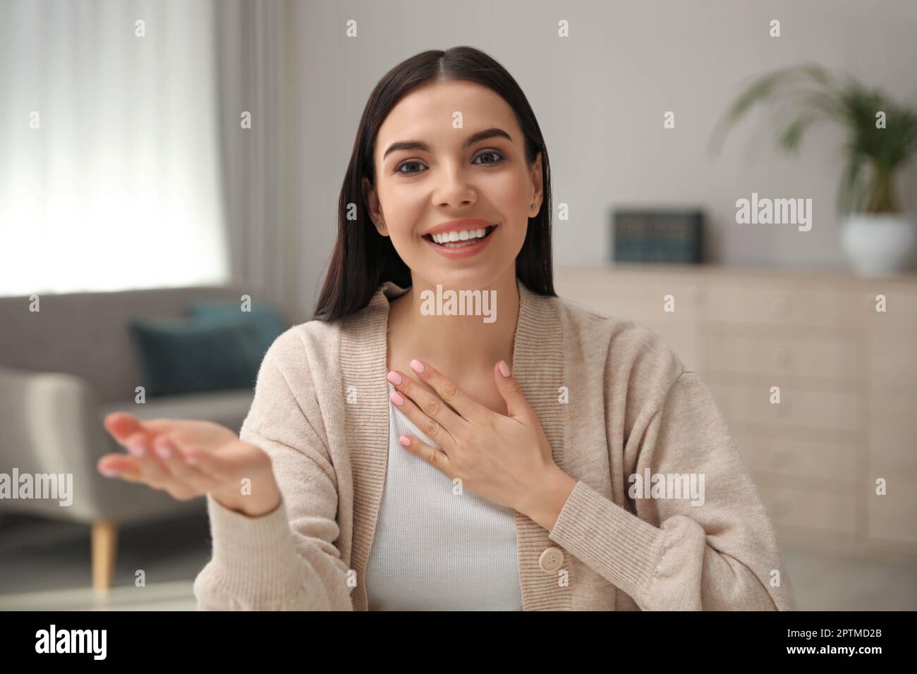Schöne junge Frau, die ein Webinar im Raum veranstaltet, Kameraansicht Stockfoto
