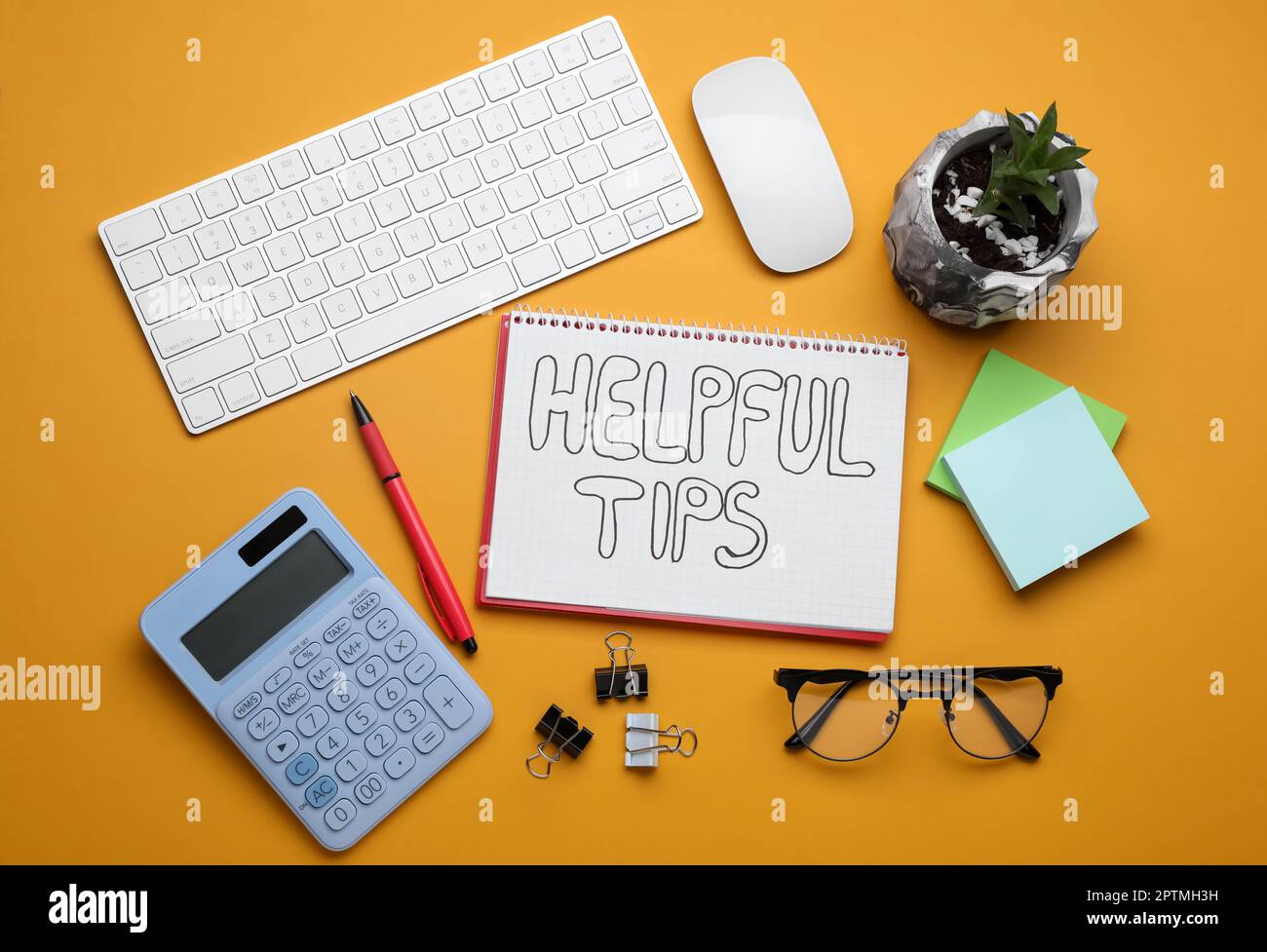 Hilfreiche Tipps. Flache Verlegung mit Notebook, Taschenrechner und Computertastatur auf orangefarbenem Hintergrund Stockfoto