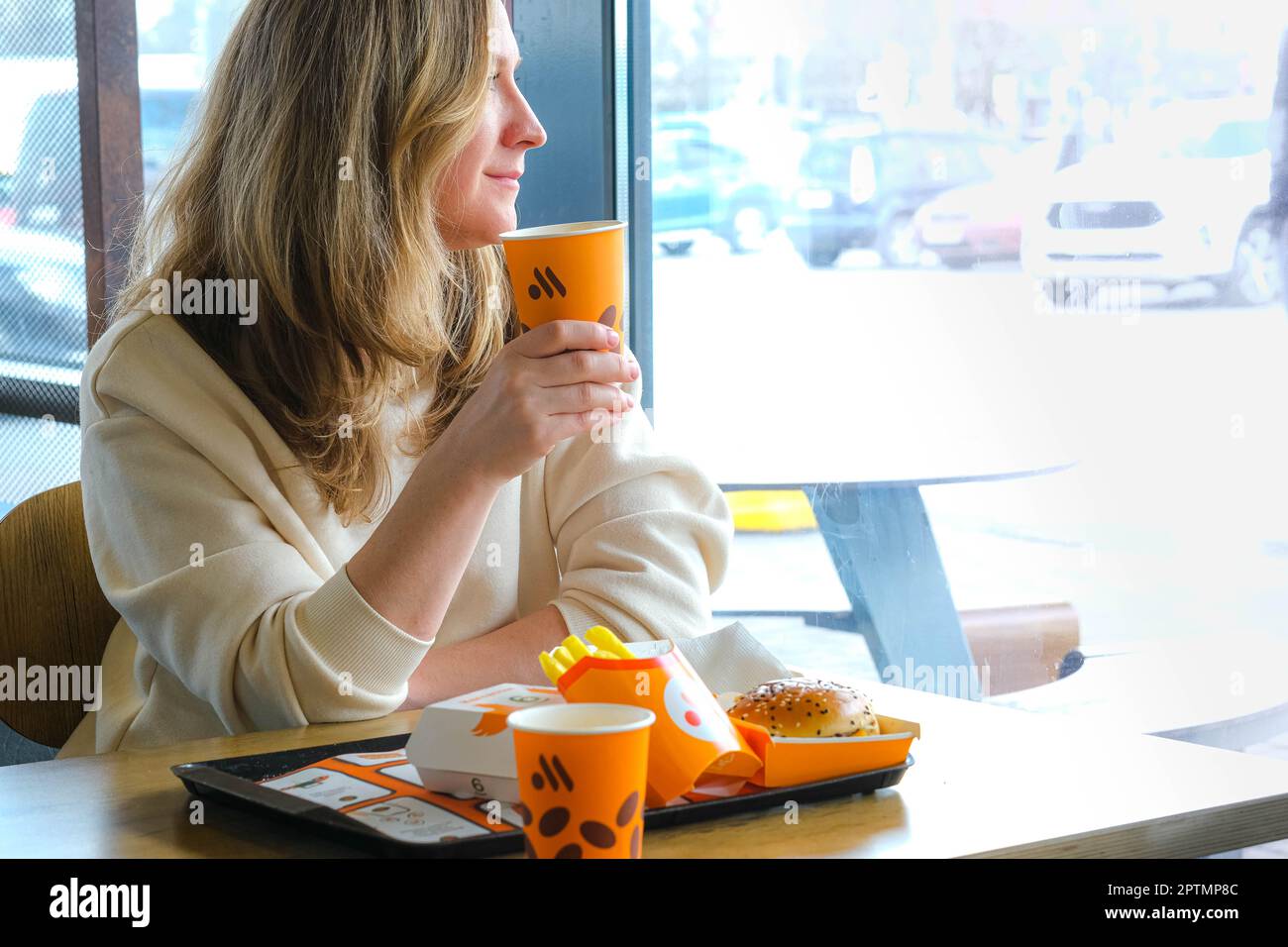 Frau isst Fast Food im russischen McDonalds Restaurant Vkusno i Tochka, Big Mac Menu, Chicken Nuggets neues Logo, Pommes Frites, Kaffee, 24.04.23 Stockfoto