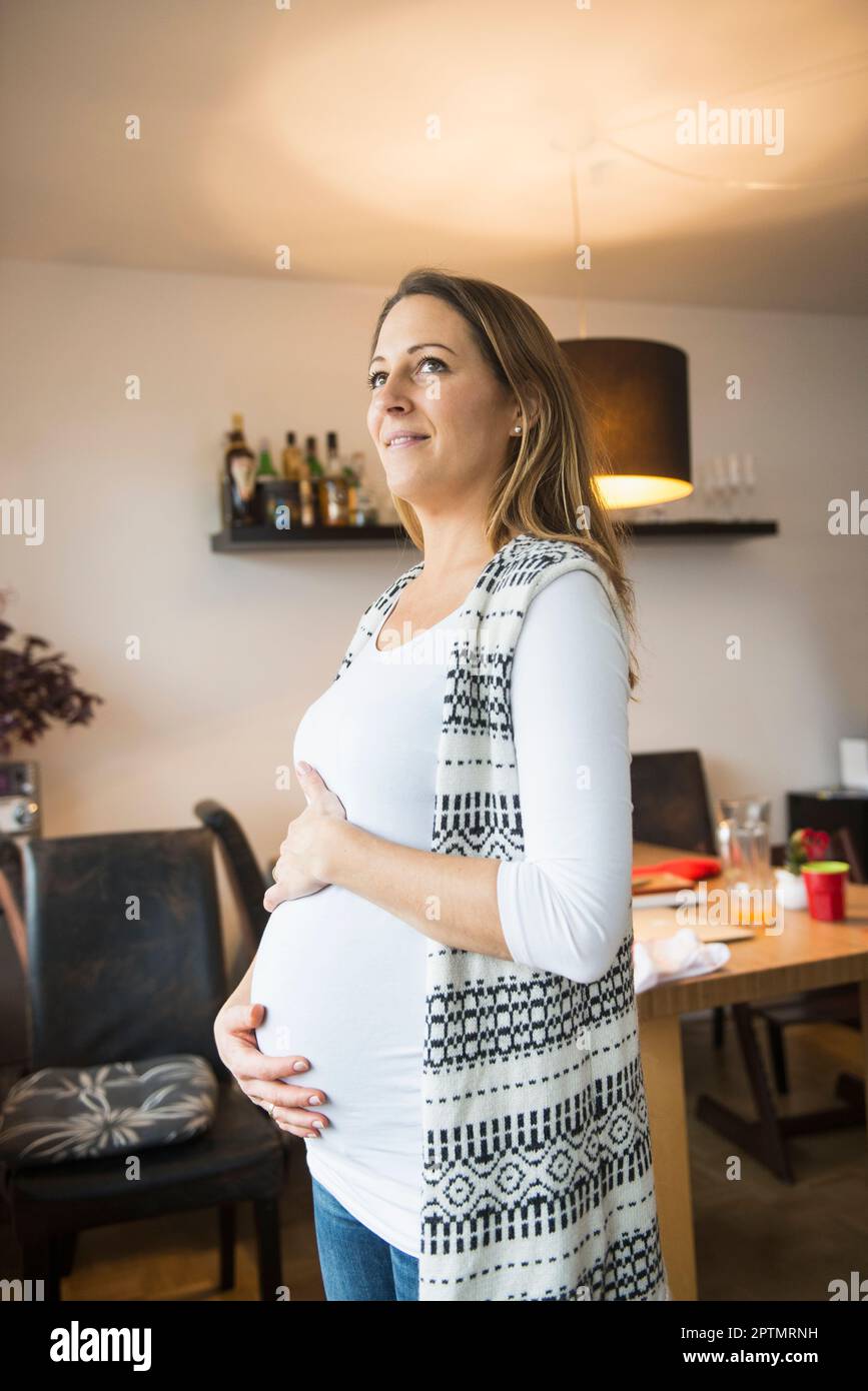 Seitenansicht einer stehenden schwangeren Frau, München Stockfoto