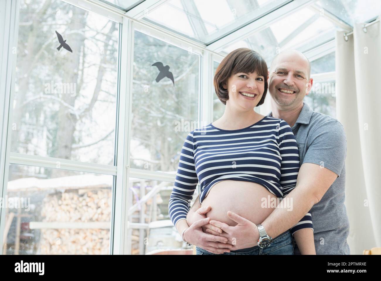 Porträt eines Mannes, der den Bauch einer schwangeren Frau hält Stockfoto