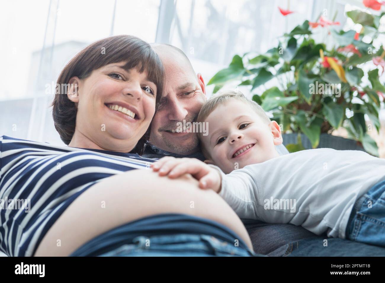 Porträt von Eltern, die mit ihrem Sohn zu Hause den Bauch der Mutter berühren Stockfoto