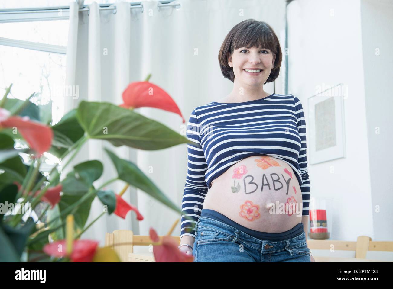 Porträt einer schwangeren Frau mit Design auf dem Bauch Stockfoto