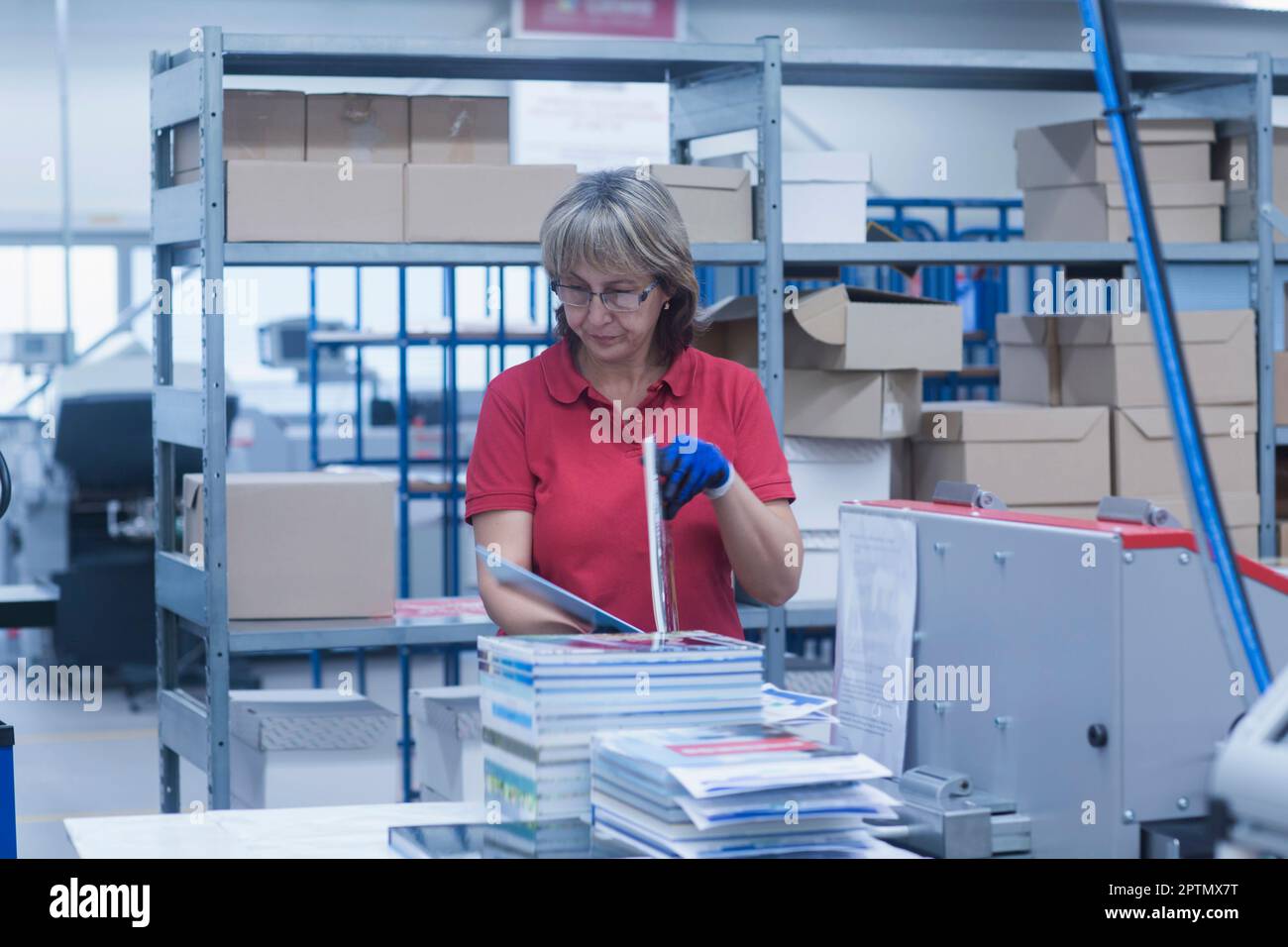 Reife Frau in der Buchdruckindustrie, Bremgarten, Hartheim am Rhein, Baden-Württemberg, Deutschland Stockfoto